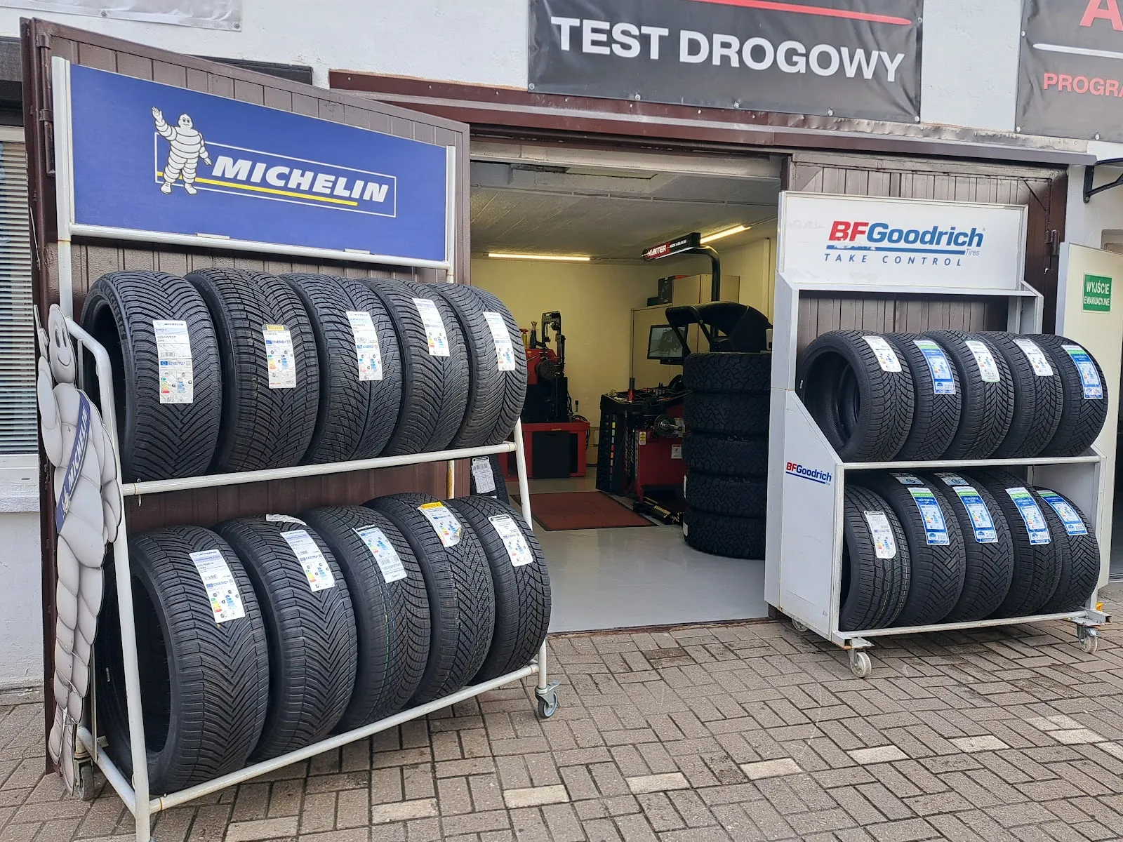 Front warsztatu Czyste Koło przy Obornickiej 252 z regałami opon Michelin i BFGoodrich oraz widokiem na halę